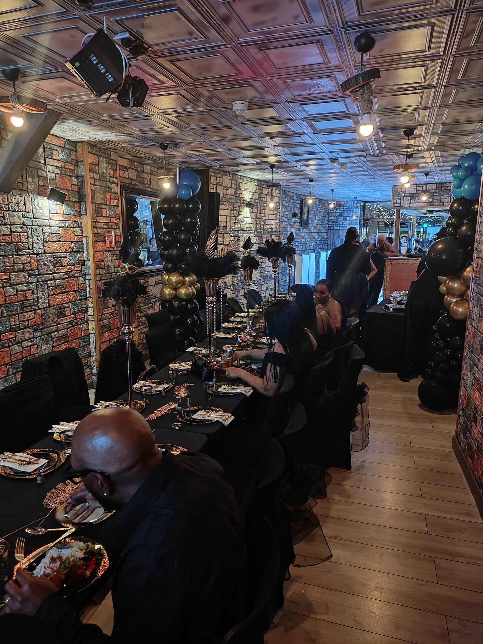 A long dining table set for a group along the brick wall of the venue.