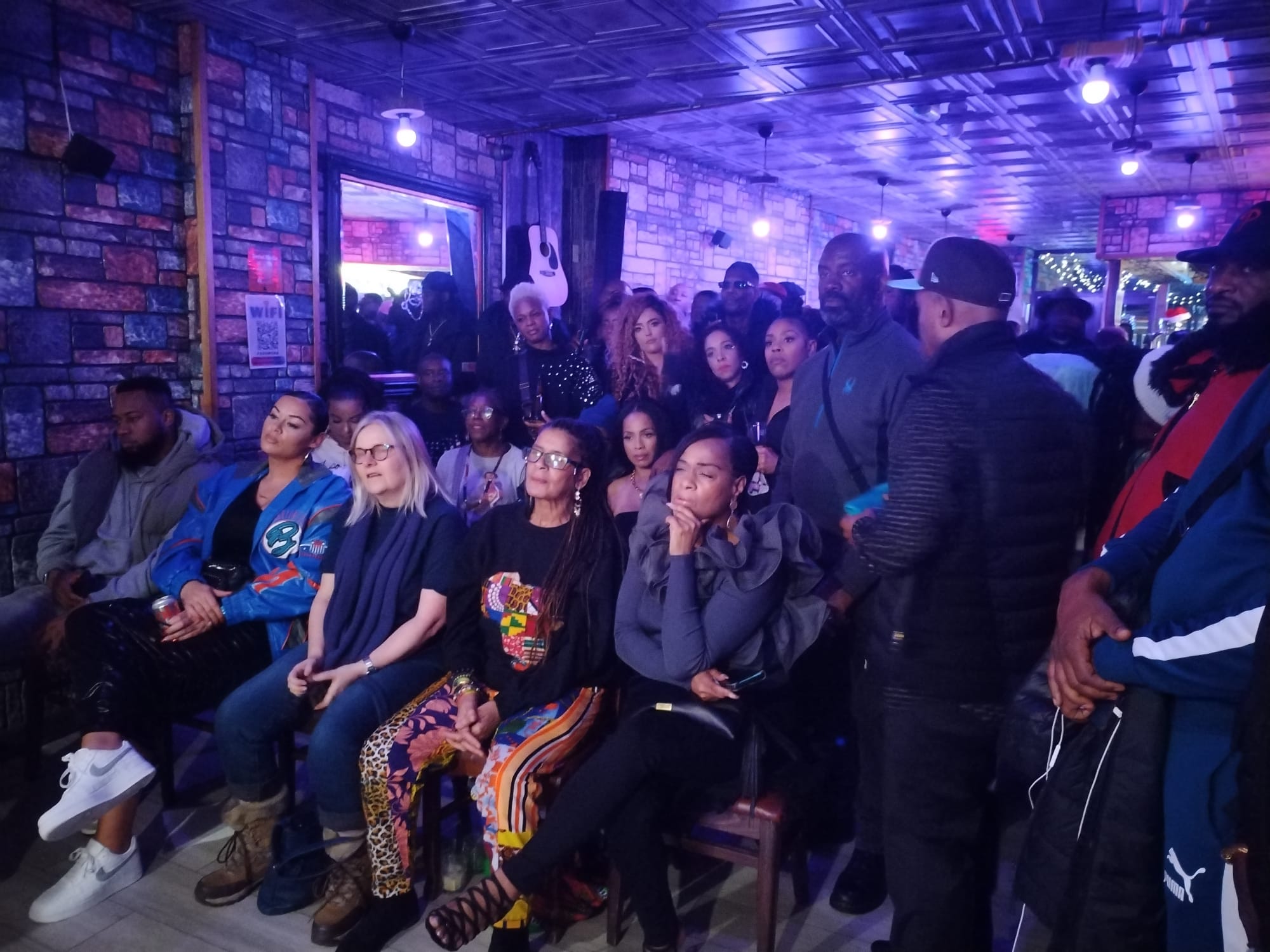 A seated audience watching a performance in the Marmalade Club main room.